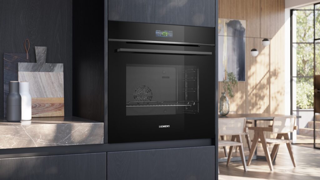 Schwarzer Siemens Einbaubackofen in moderner Küche mit dunklen Fronten und hellem Essbereich im Hintergrund.