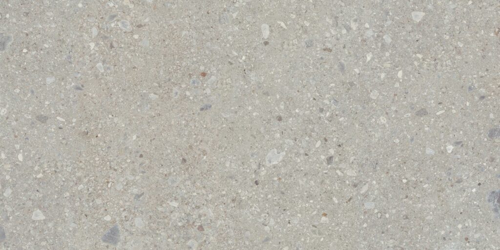 Detailaufnahme einer hellgrauen Oberfläche in Steinoptik mit feiner Körnung und natürlichen Einschlüssen.