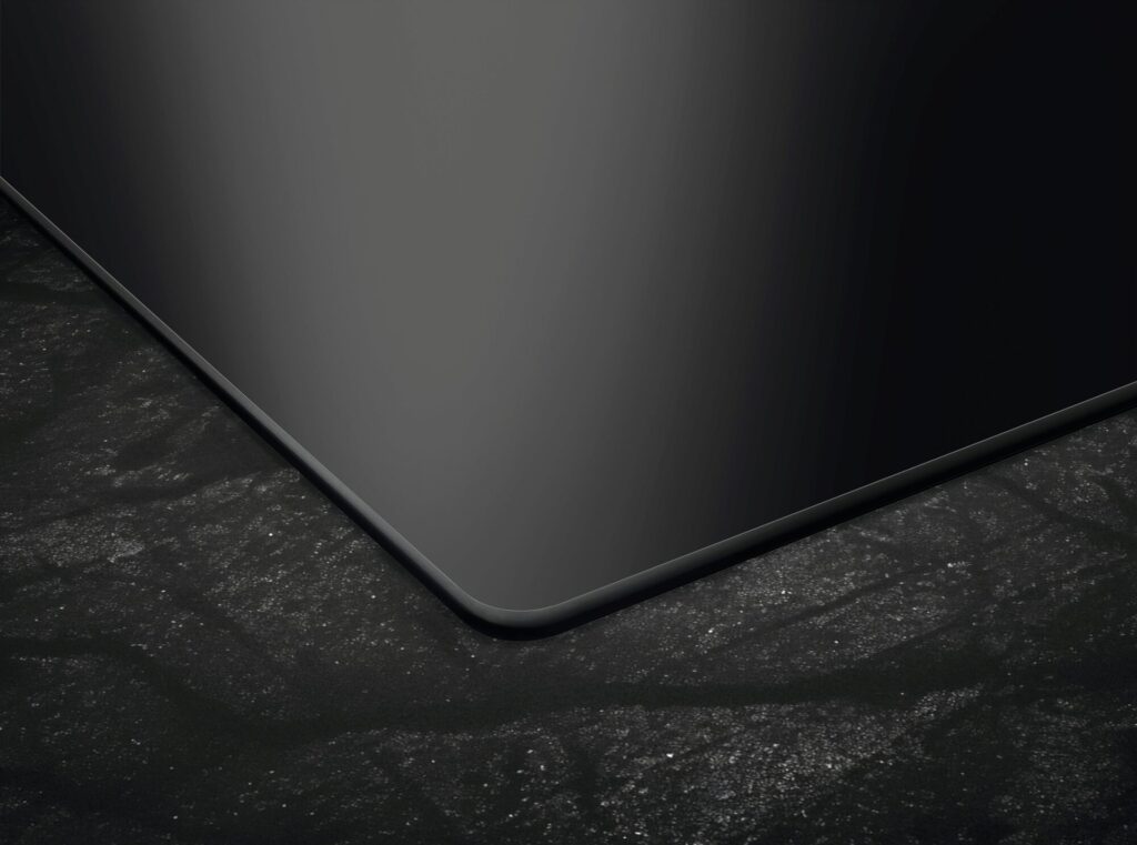 Detailaufnahme der Glaskeramik-Oberfläche eines AEG Induktionskochfelds in der Küche.