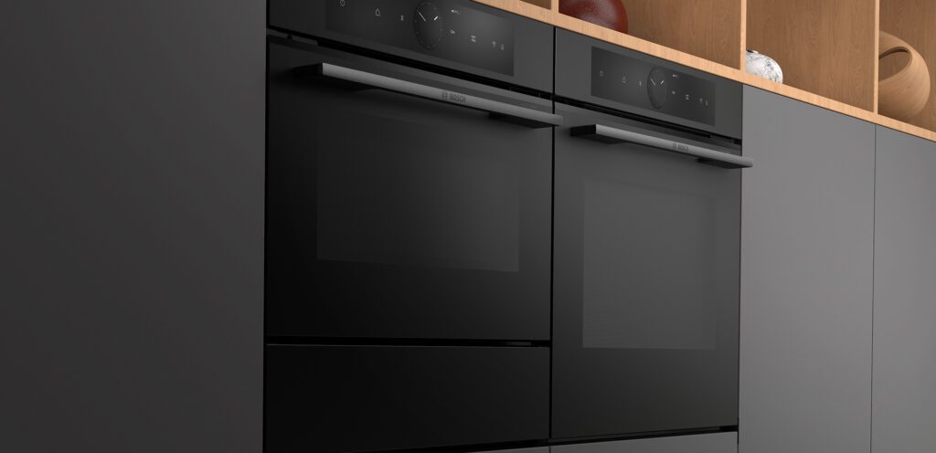 Nahaufnahme von zwei nebeneinander eingebauten, mattschwarzen Bosch Backöfen mit digitalem Display und eleganten Griffen.