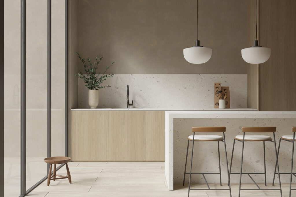 Eine moderne Küche mit Kochinsel im Terrazzo-Look, hellen Holzschränken und minimalistischer Dekoration.